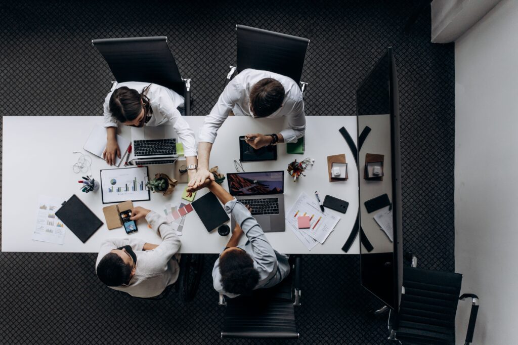 High angle view of colleagues collaborating around a conference table in a modern office setting.